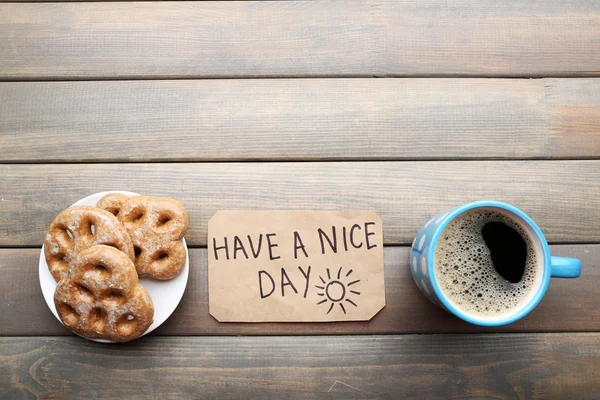 Taza de café con croissant fresco y tener un buen día de masaje en la mesa de madera, vista superior — Foto de Stock