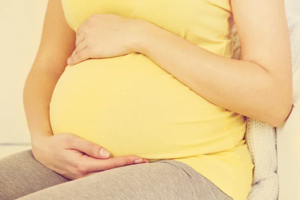 Młoda kobieta w ciąży na kanapie, szczelnie-do góry — Zdjęcie stockowe
