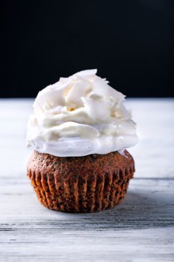 Lezzetli Hindistan cevizi kek krem rengi ahşap masa ve koyu arka plan