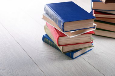 Ahşap zemin üzerine kitap yığınları