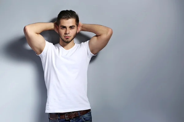 Young man on gray background — Stock Photo, Image