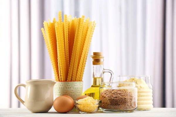 Massa com azeite, ovos, queijo e farinha sobre mesa de madeira sobre fundo cortina — Fotografia de Stock