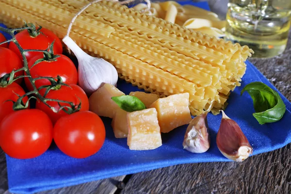 Pasta con pomodorini e altri ingredienti su fondo tavola in legno — Foto Stock