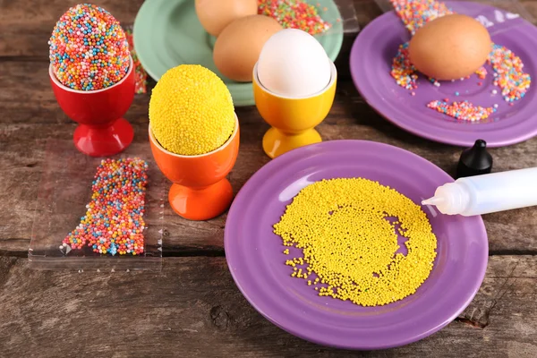 Decoration Easter eggs with colorful beads on wooden table, closeup — Stock Photo, Image