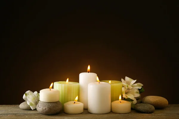 Hermosa composición con velas y piedras de spa sobre fondo oscuro — Foto de Stock