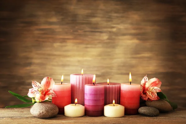 Nádherná skladba se svíčkami a wellness kameny na dřevěné pozadí — Stock fotografie