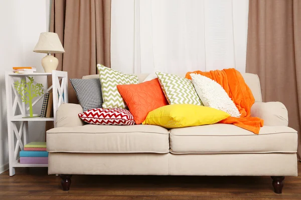 Диван з різнокольоровими подушками в кімнаті — стокове фото