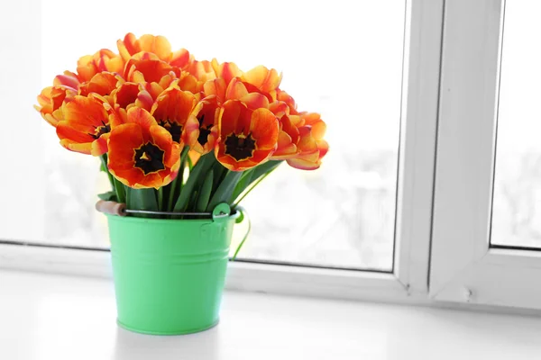 Beautiful bouquet of tulips in metal bucket on windowsill — Stock Photo, Image