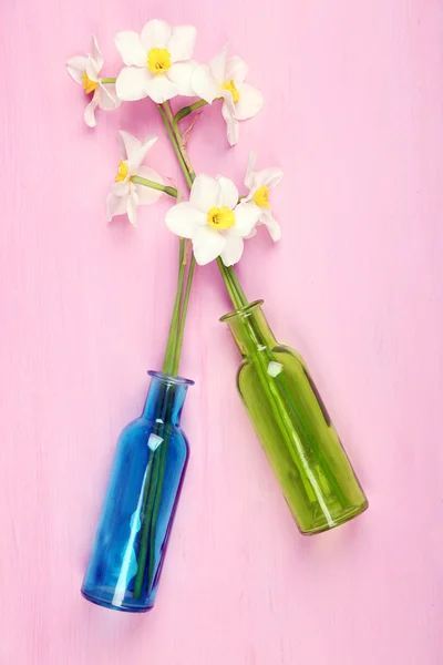 Vackra påskliljor i vaser på trä bakgrund — Stockfoto