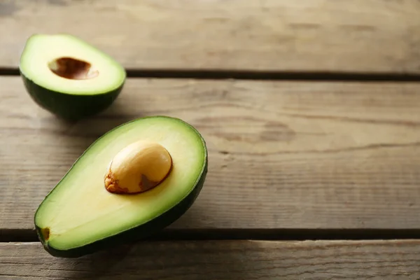 Sliced avocado on wooden background — Stock Photo, Image