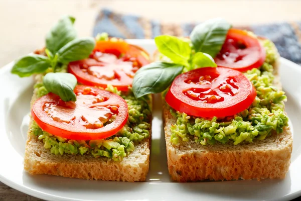 Sanduíche Vegan com abacate e legumes na placa, no fundo de madeira — Fotografia de Stock