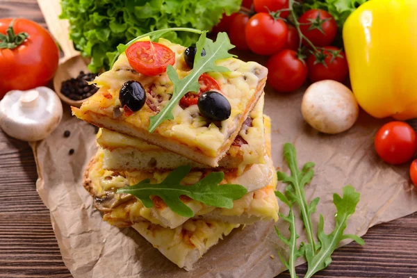 Leckere hausgemachte Pizza auf dem Tisch aus nächster Nähe — Stockfoto