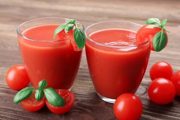 Vasos de jugo de tomate con verduras sobre fondo de madera — Foto de Stock