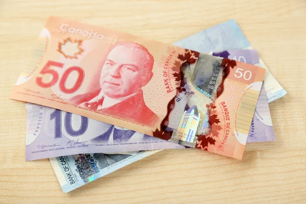 Канадские доллары на деревянном столе — стоковое фото