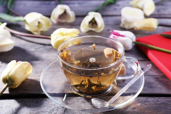 Kopje kruidenthee met bloemen op houten tafel, close-up — Stockfoto