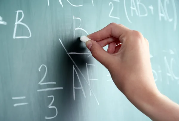 Hand schrijven van formules op blackboard — Stockfoto