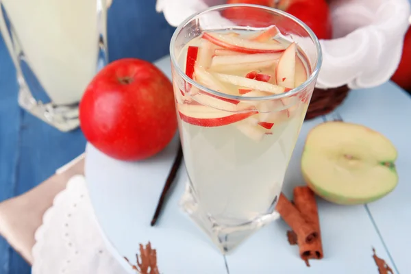 Glass of apple cider with fruits and spices on table close up — Stock Photo, Image