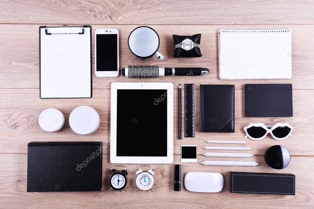 Set of black and white accessories on wooden table, top view
