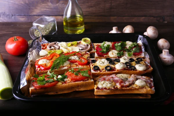 Sanduíches diferentes com verduras e queijo na panela na mesa de perto — Fotografia de Stock