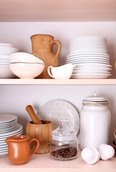 Kitchen utensils and tableware on wooden shelves — Stock Photo, Image