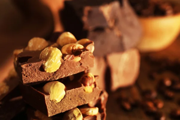 Stack of chocolate with nuts on wooden table, closeup — Stock Photo, Image