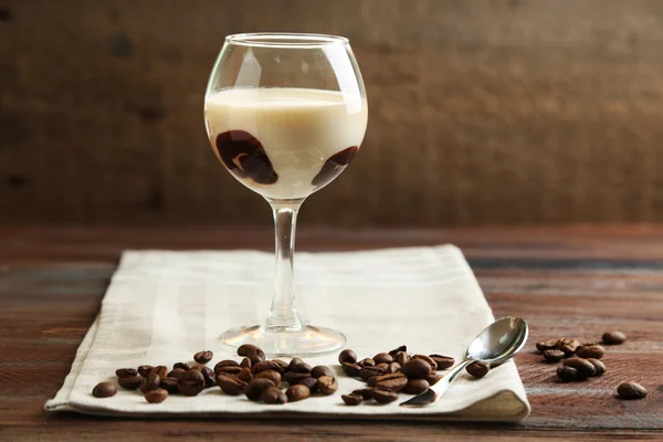 Vaso de sabroso panna cotta postre en plato, sobre mesa de madera —  Fotos de Stock