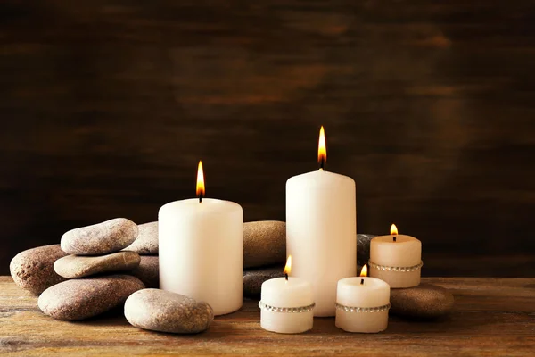 Hermosa composición con velas y piedras de spa sobre fondo de madera —  Fotos de Stock