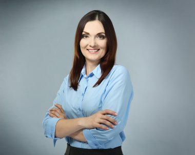 Gri arka plan üzerinde güzel orta yaşlı iş kadını