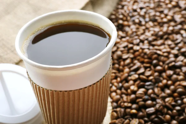 Бумажная чашка кофе с бобами — стоковое фото