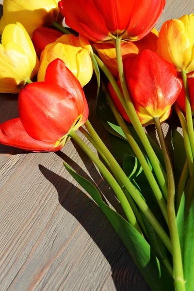 Bellissimi tulipani colorati su tavolo di legno, primo piano — Foto Stock