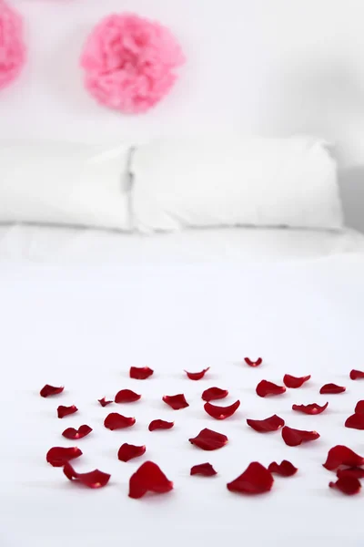 Red petals on bed — Stock Photo, Image