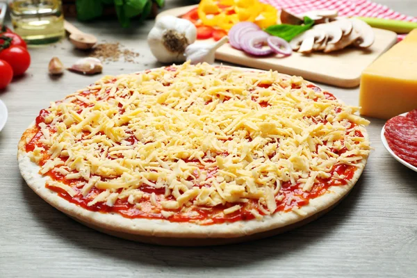 Raw pizza on table — Stock Photo, Image