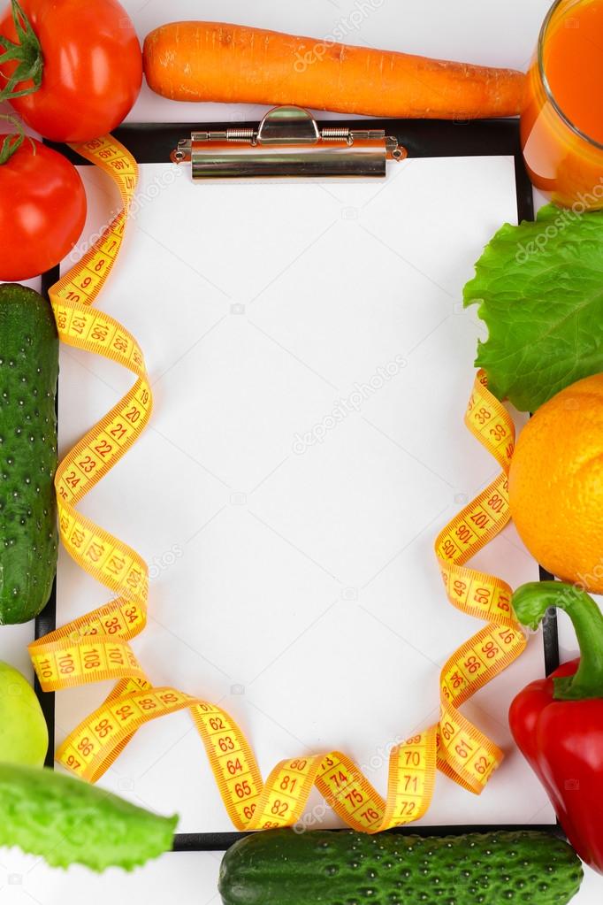 Clipboard for diet plan with vegetables and measuring tape, closeup