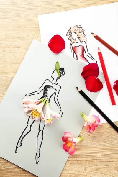 Picture with flower petals and pencils on wooden table