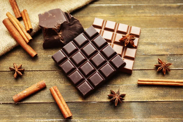 Zátiší s nastaveným čokolády s kořením na dřevěné pozadí — Stock fotografie