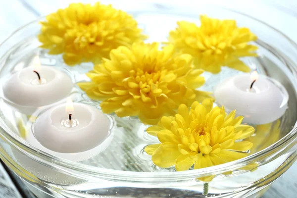 Ciotola di acqua termale con fiori e candele, primo piano — Foto Stock