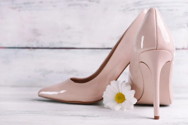 Female shoes with flower on wooden background — Stock Photo, Image