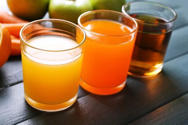 Assortment of healthy fresh juices and fruits on wooden table background — Stock Photo, Image