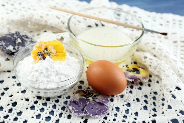 Tvorba kandované fialové květy s bílky a cukr, na barevné dřevěné pozadí — Stock fotografie