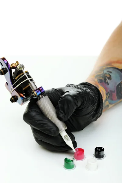 Hand van tatoeage kunstenaar met tattoo machine — Stockfoto