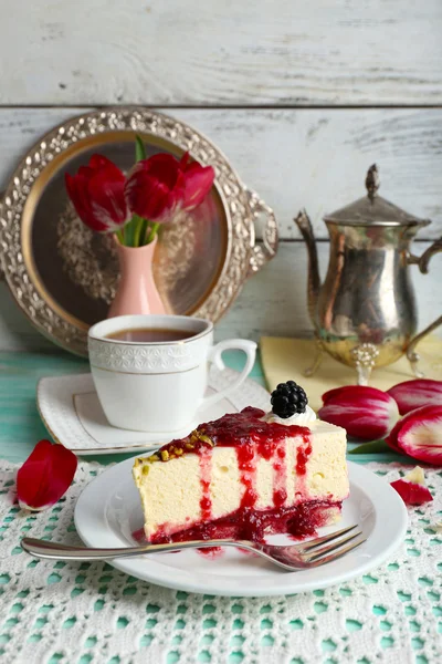 Lekker stukje cheesecake met berry saus op plaat op tafel close-up — Stockfoto