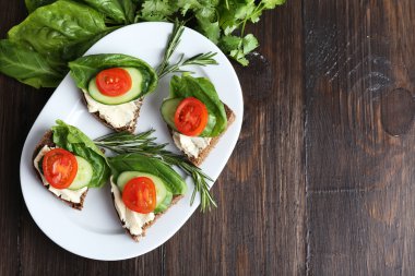 sebze ve ahşap masa üzerinde yeşillik ile lezzetli sandviçler