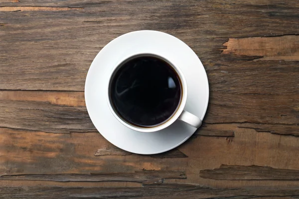 Kopje koffie op houten tafel, bovenaanzicht — Stockfoto