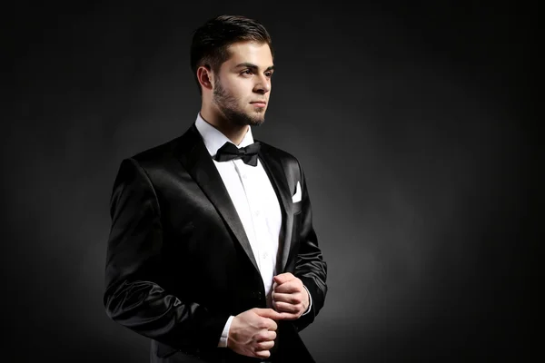 Elegante man in pak op donker — Stockfoto