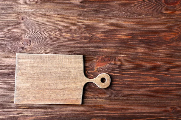 Cutting board on wooden background — Stock Photo, Image