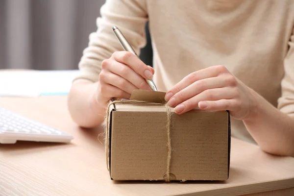 Woman signs parcel in post office — Stock Photo, Image