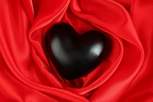 Corazón negro sobre fondo de tela — Foto de Stock