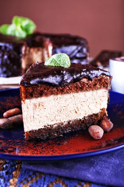 Köstlicher Schokoladenkuchen mit Zuckerguss im Teller auf dem Tisch, Nahaufnahme — Stockfoto