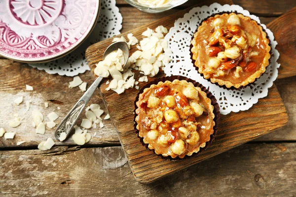 Mini cakes with nuts on wooden background — Stock Photo, Image