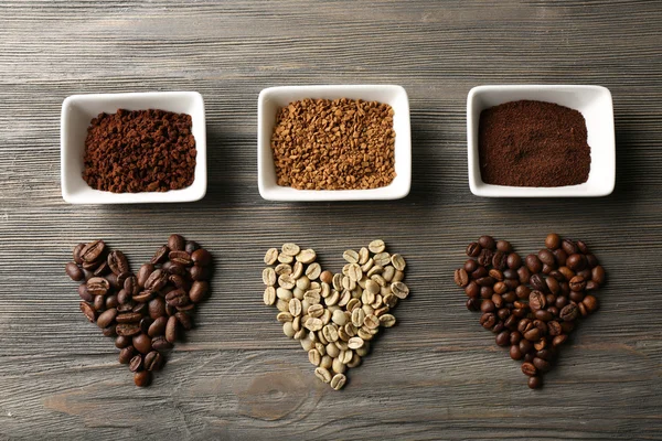 Chicchi di caffè a forma di cuore su sfondo di legno — Foto Stock